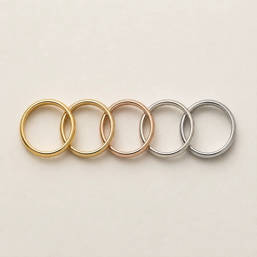 Five wedding bands overlapping in a row: yellow gold, rose gold, white gold and platinum side by side